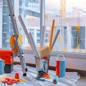 A variety of painting supplies in an upper room of a commercial building in front of a large window