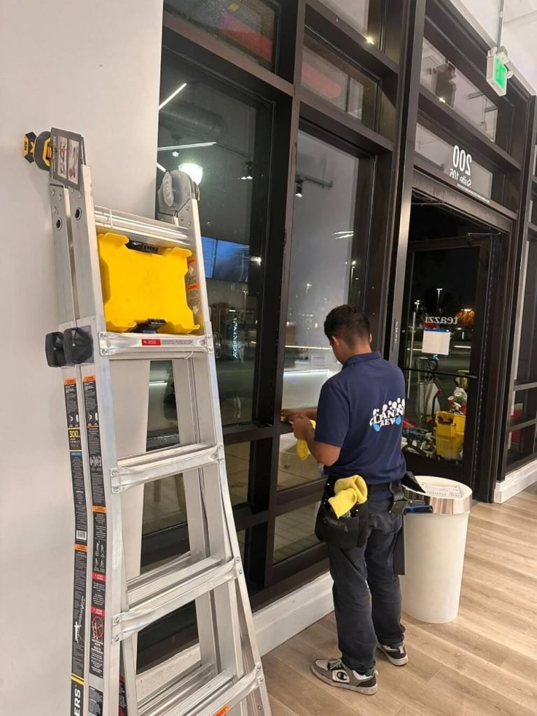 A janitor is wiping down a windowsill.